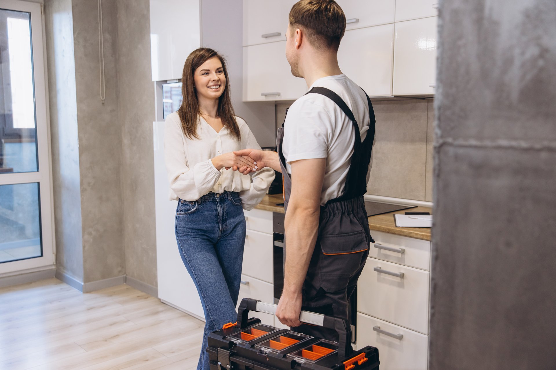 Professional handyman shaking hands with homeowner after completing work